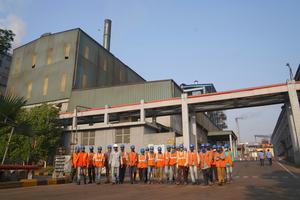 Photo of employees in India standing outside a factory
