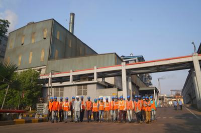 Photo of employees in India standing outside a factory